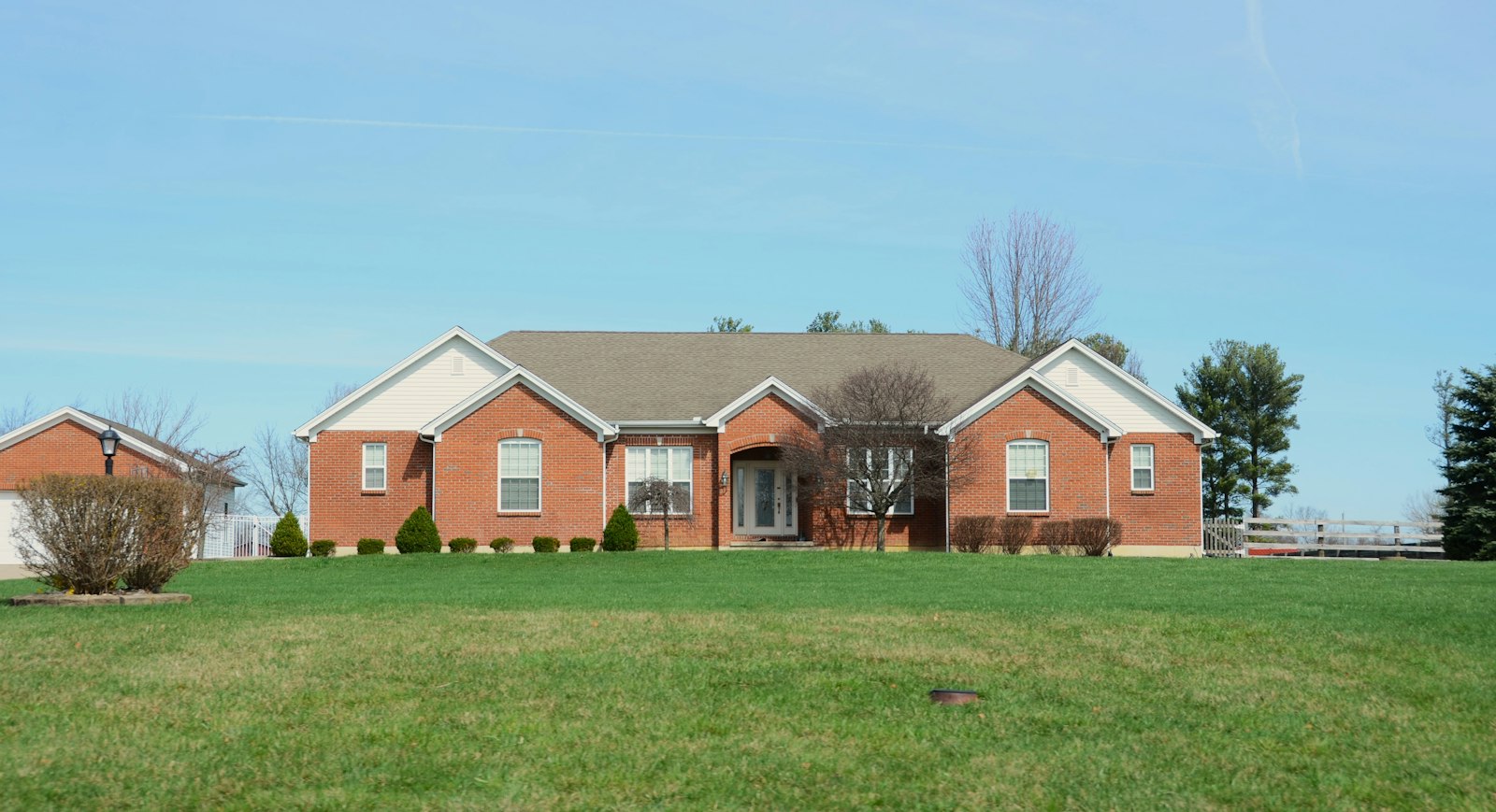 A large brick house with a manicured lawn